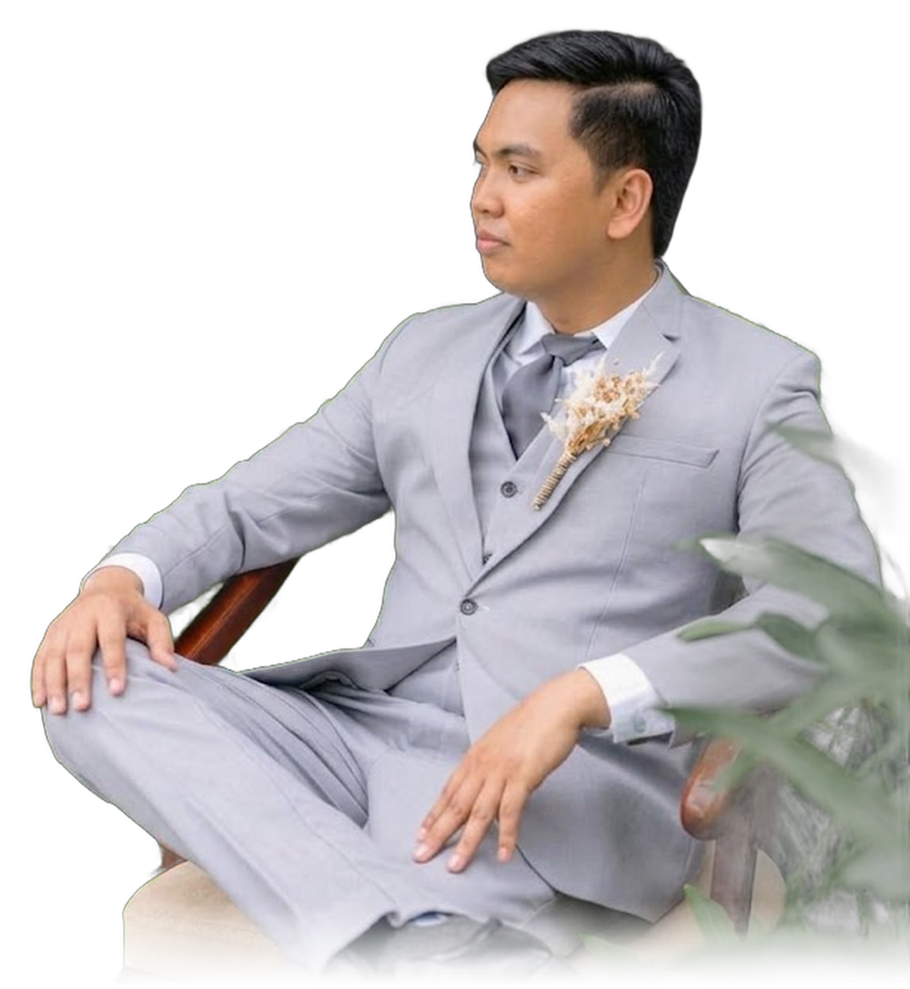 Harvey sitting in a grey suit, looking to the side